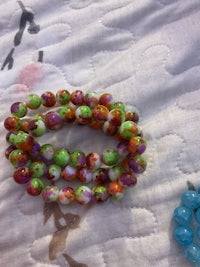 a group of colorful glass beads on a bed