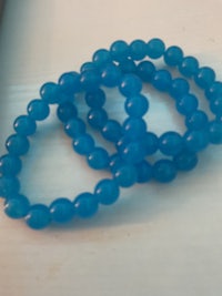 a blue beaded bracelet sitting on a table