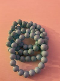 a stack of blue beads on a pink surface