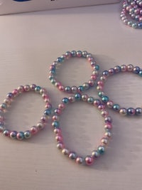 a group of bracelets with pink and blue beads on them