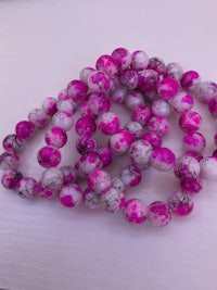 pink and white marble beads on a white surface