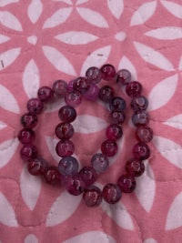 a pair of purple beads on a pink blanket