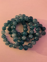 a stack of green beads on a pink background