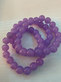 a bunch of purple beads on a table