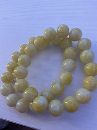 a yellow jade beaded bracelet on a table