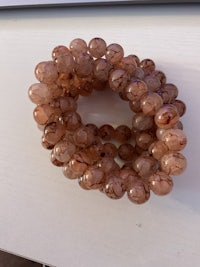 a bracelet with brown beads on top of a table