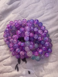 purple and blue glass beads laying on a bed