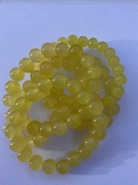 a bunch of yellow beads on a white surface