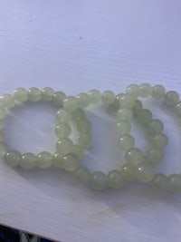 three green jade beads on a table